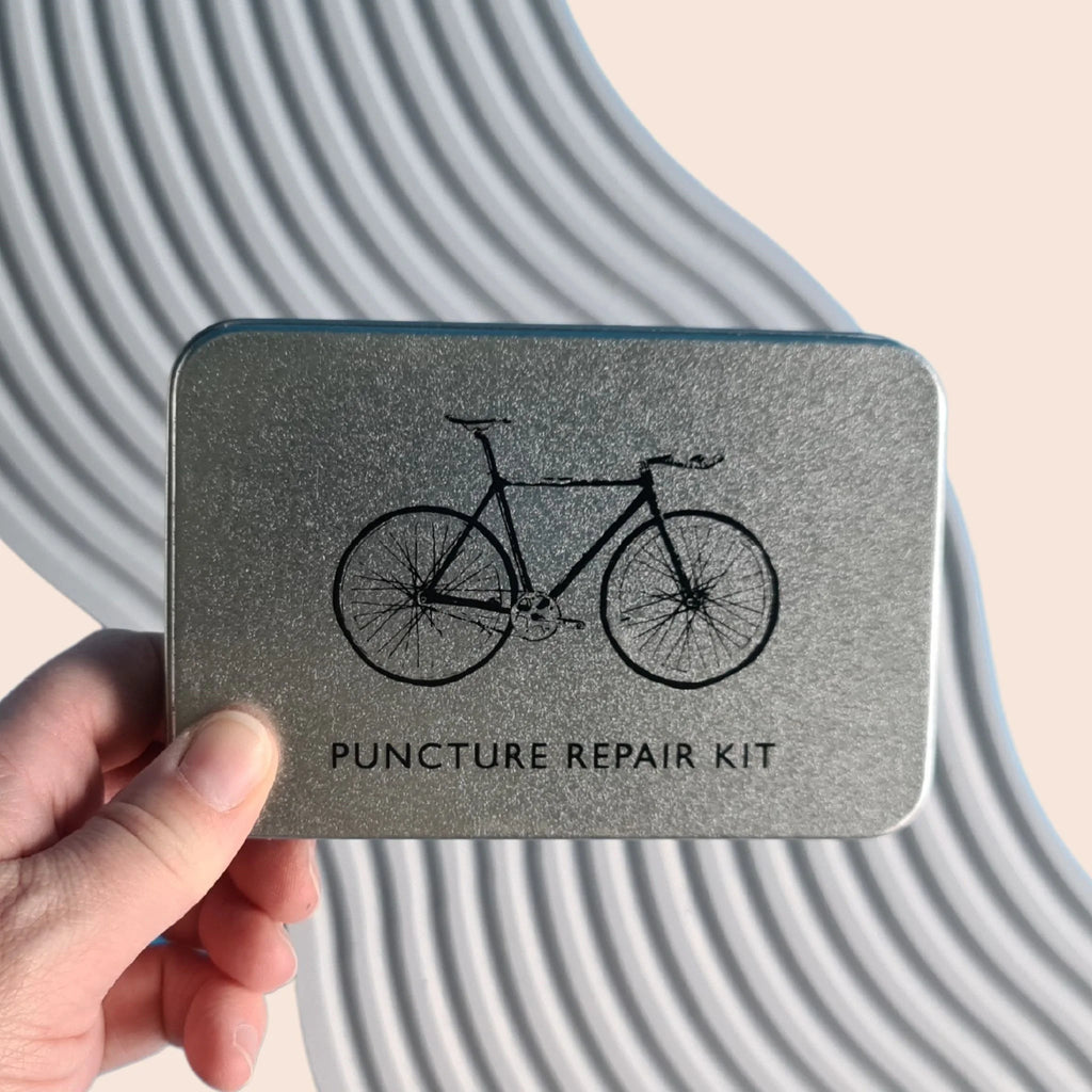 metal tin with bike on the front  containing a 22 piece puncture repair kit