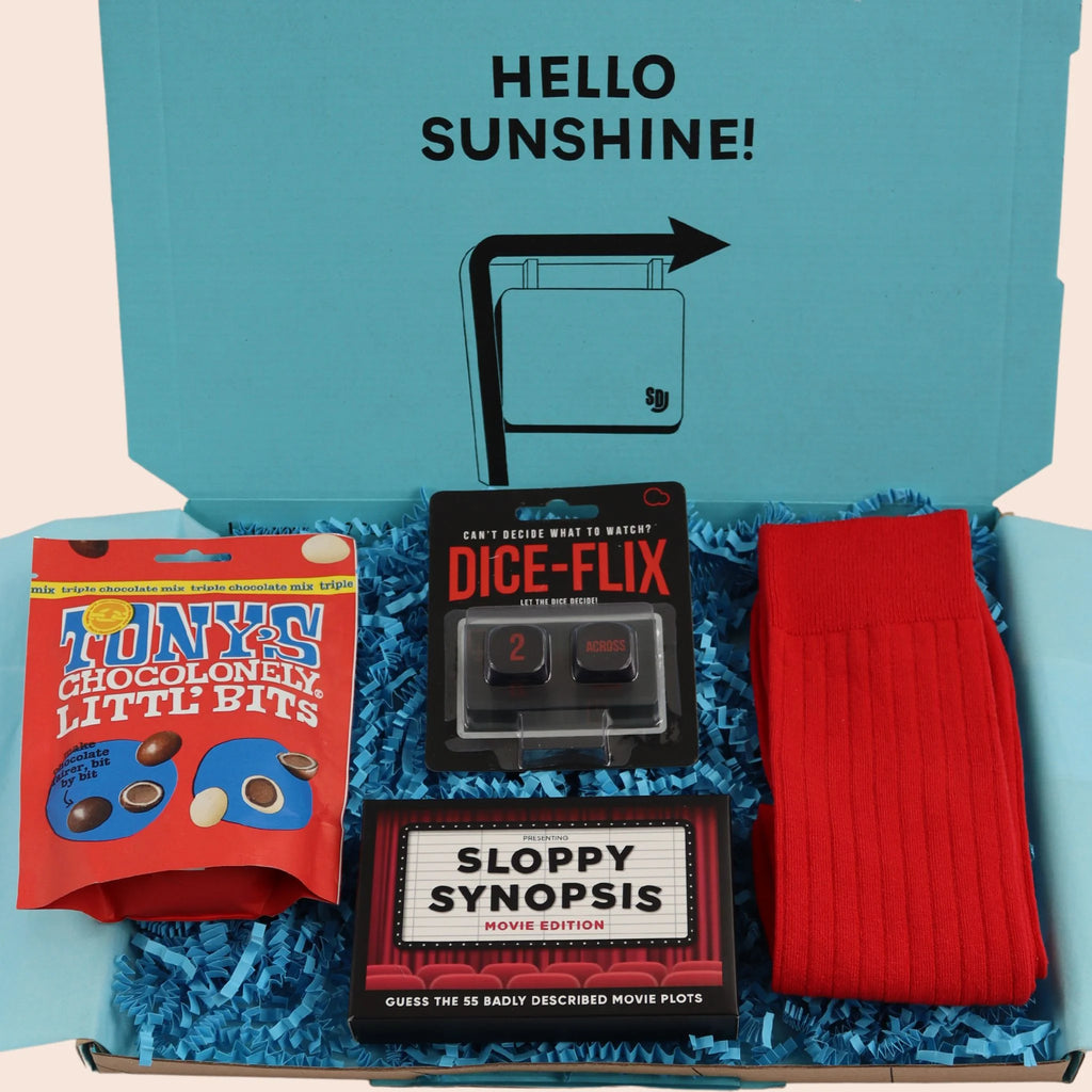 turquoise gift box with the words hello sunshine. The box contains Tonys chocolate, sloppy synopsis movie themed game, dice-flix, and red socks. The packaging is plastic free with turquoise tissue with turquoise paper shred